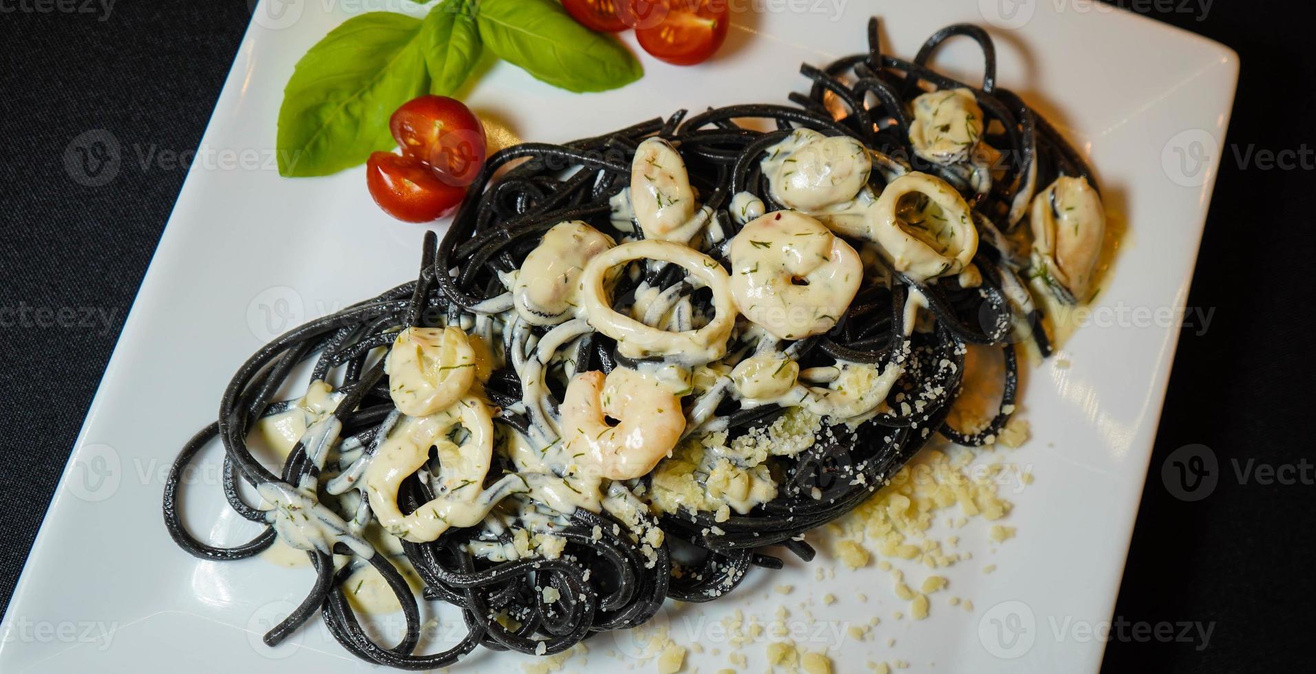 spaghetti rigate - zwarte pasta met gemengde zeevruchten foto