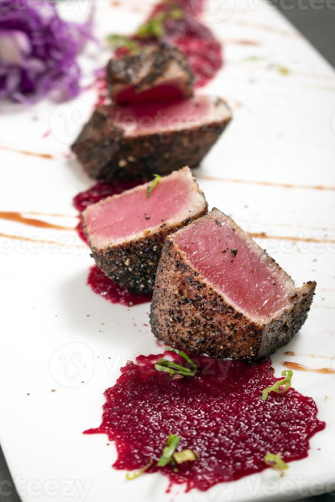 gourmet aangebraden tonijn in zwarte peperkorst met rode biet en frambozencoulis foto