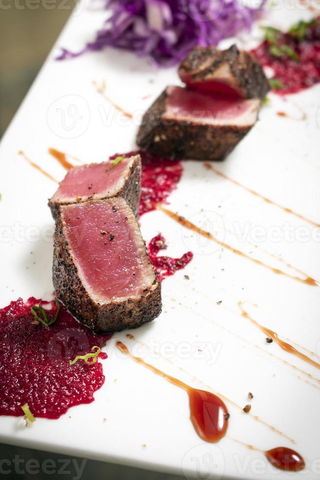 gourmet aangebraden tonijn in zwarte peperkorst met rode biet en frambozencoulis foto