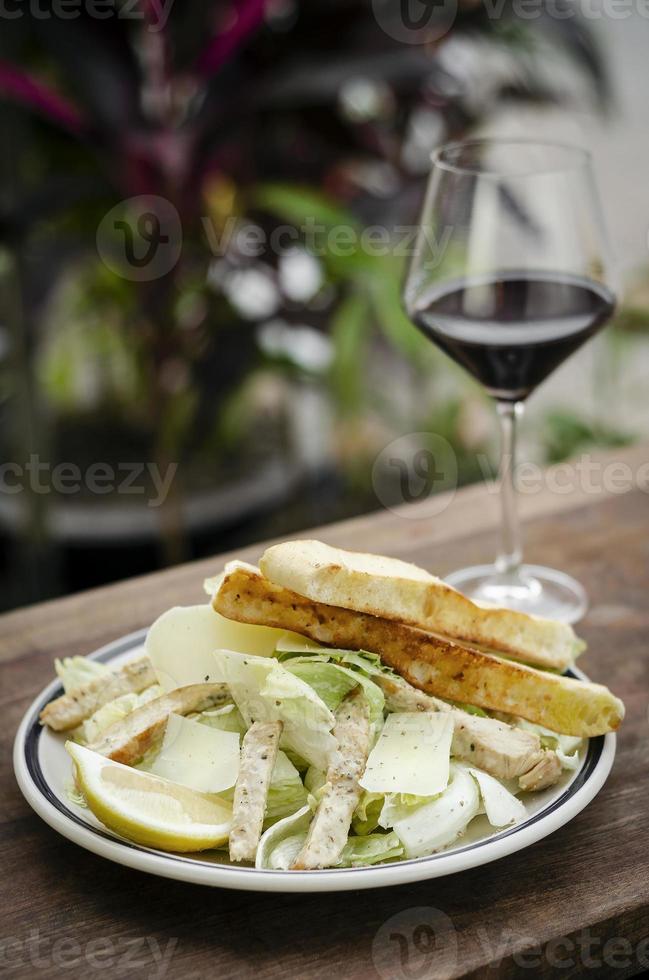 eenvoudige gezonde biologische kip Caesarsalade op houten tafel foto