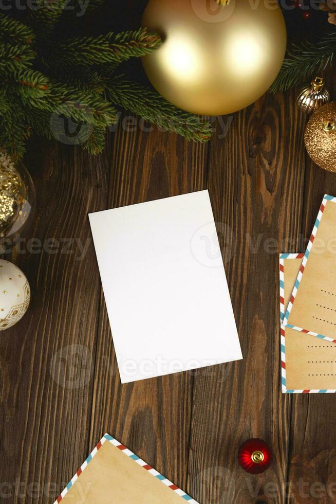 Kerstmis kaart model. wit minimaal leeg ansichtkaart Aan houten tafel met feestelijk decoraties en ambacht brieven. foto