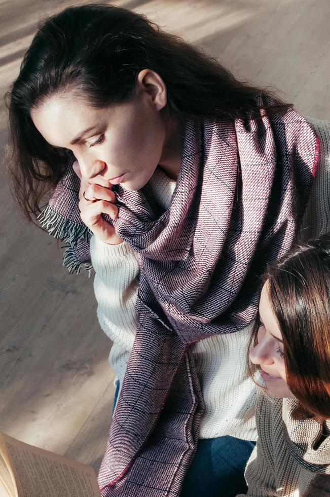 charmante studentenmeisjes die over een boek zitten foto