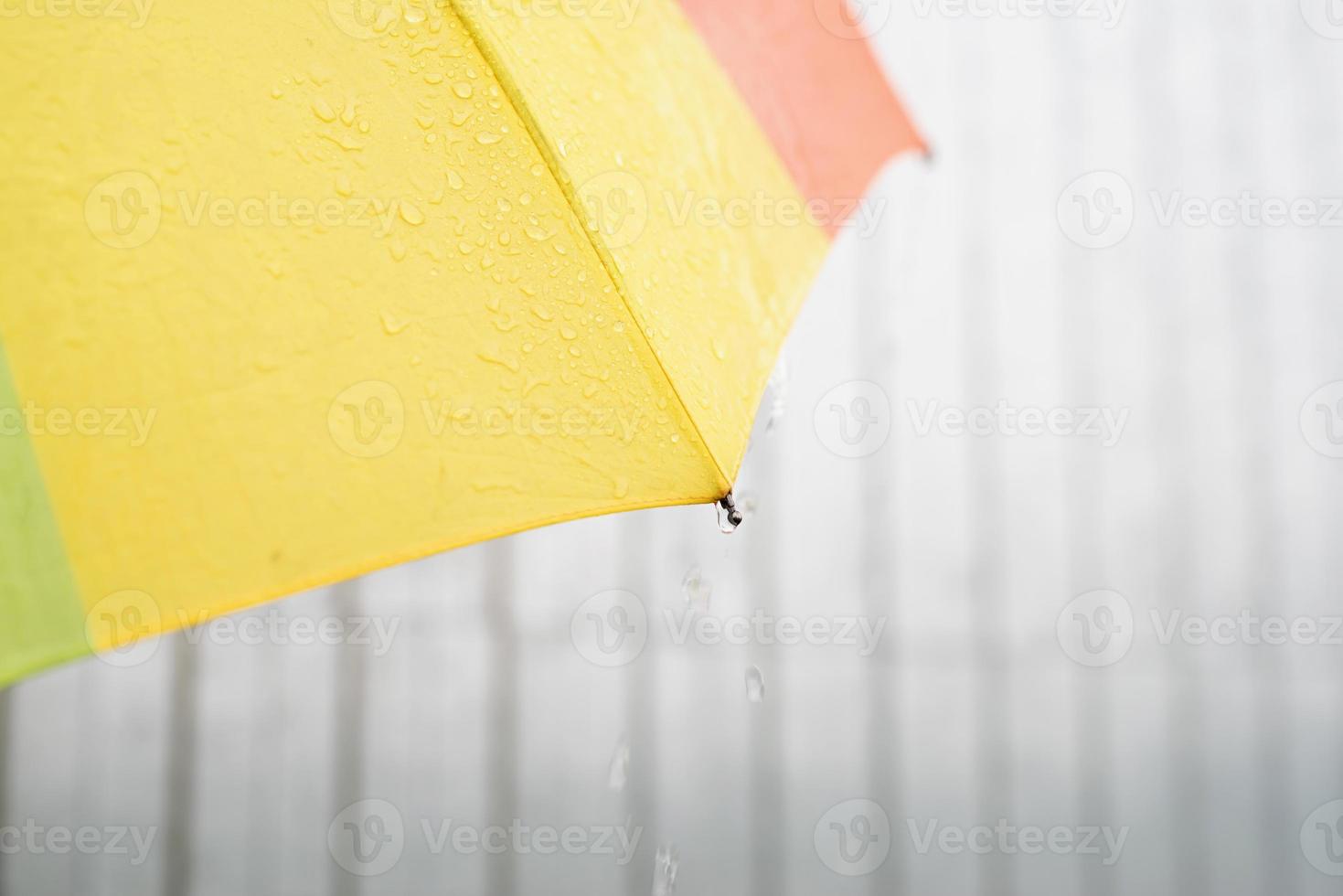 close-up van kleurrijk paraplugedeelte met regendruppels foto