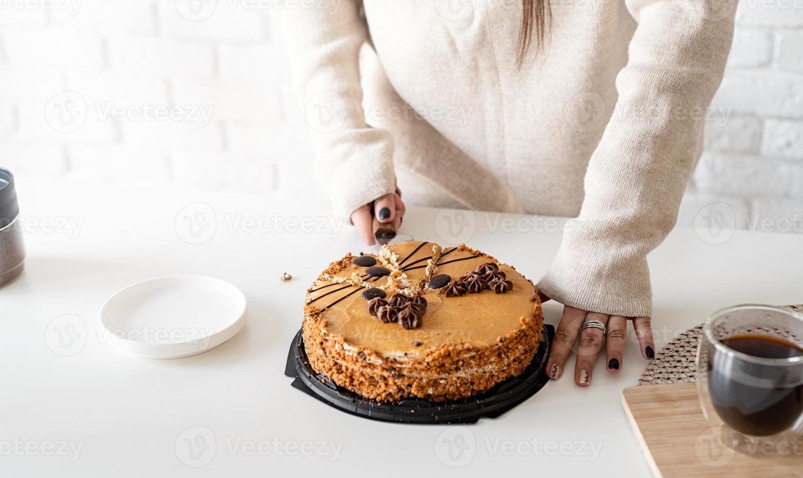 close-up van vrouwenhanden die een cake snijden foto