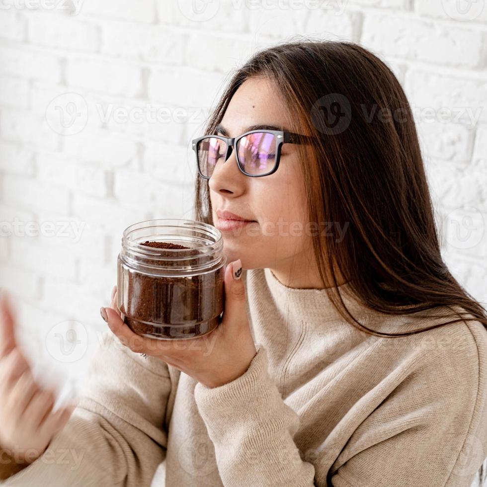 vrouw koffie zetten in koffiepot, ruiken gemalen koffiebonen foto