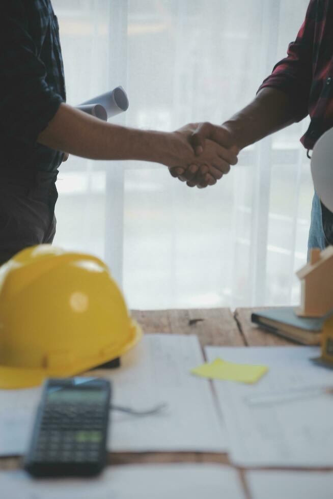 dichtbij omhoog van civiel mannetje ingenieur Aziatisch werken Aan blauwdruk bouwkundig project Bij bouw plaats Bij bureau in kantoor. foto