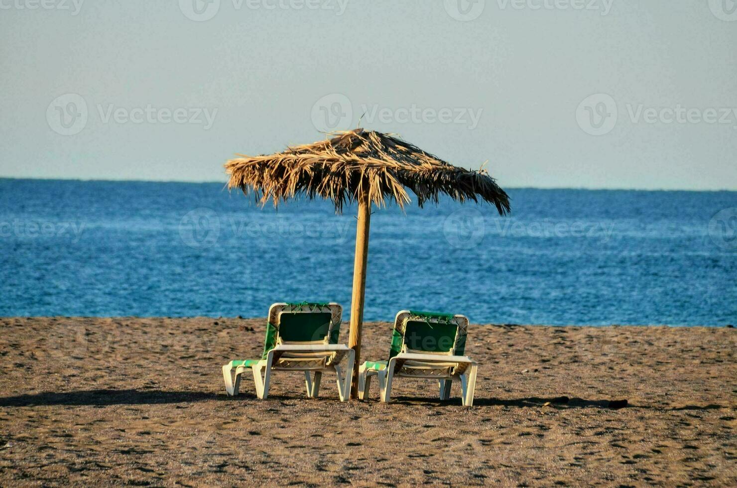 twee stoelen en een paraplu Aan de strand foto