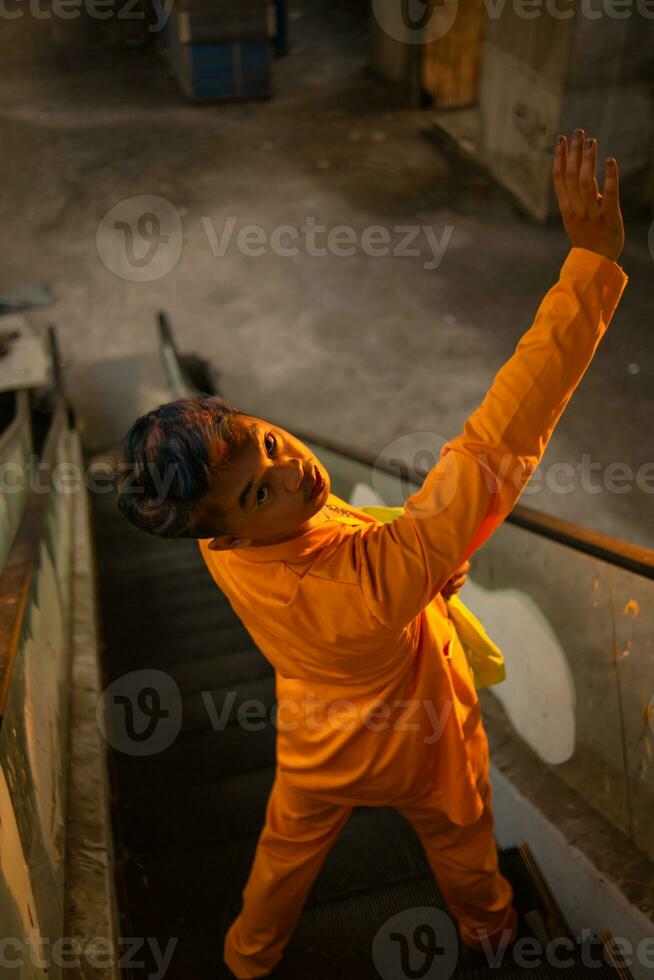 een Aziatisch Mens staand in voorkant van de venster van een verlaten gebouw terwijl vervelend een geel blazer foto