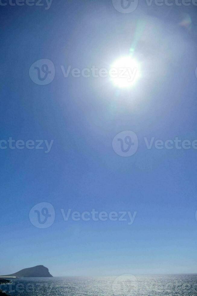 de zon schijnt helder over- de oceaan foto