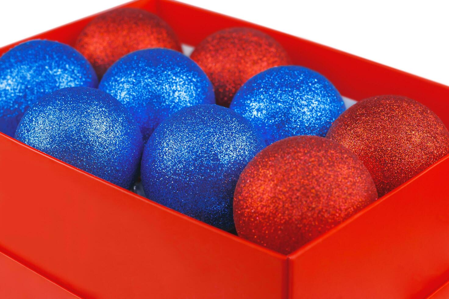 rood en blauw Kerstmis ornament met sparkles in rood verpakking Aan een wit achtergrond. foto