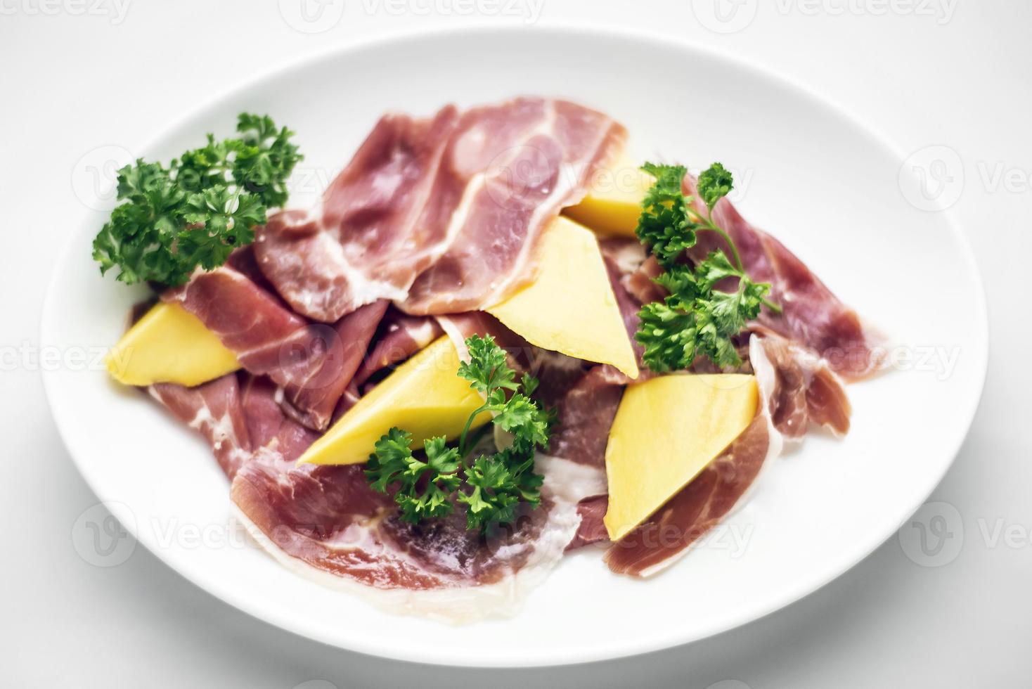 jamon serrano parma prosciutto stijl gerookte ham met mango fruit starter tapas foto