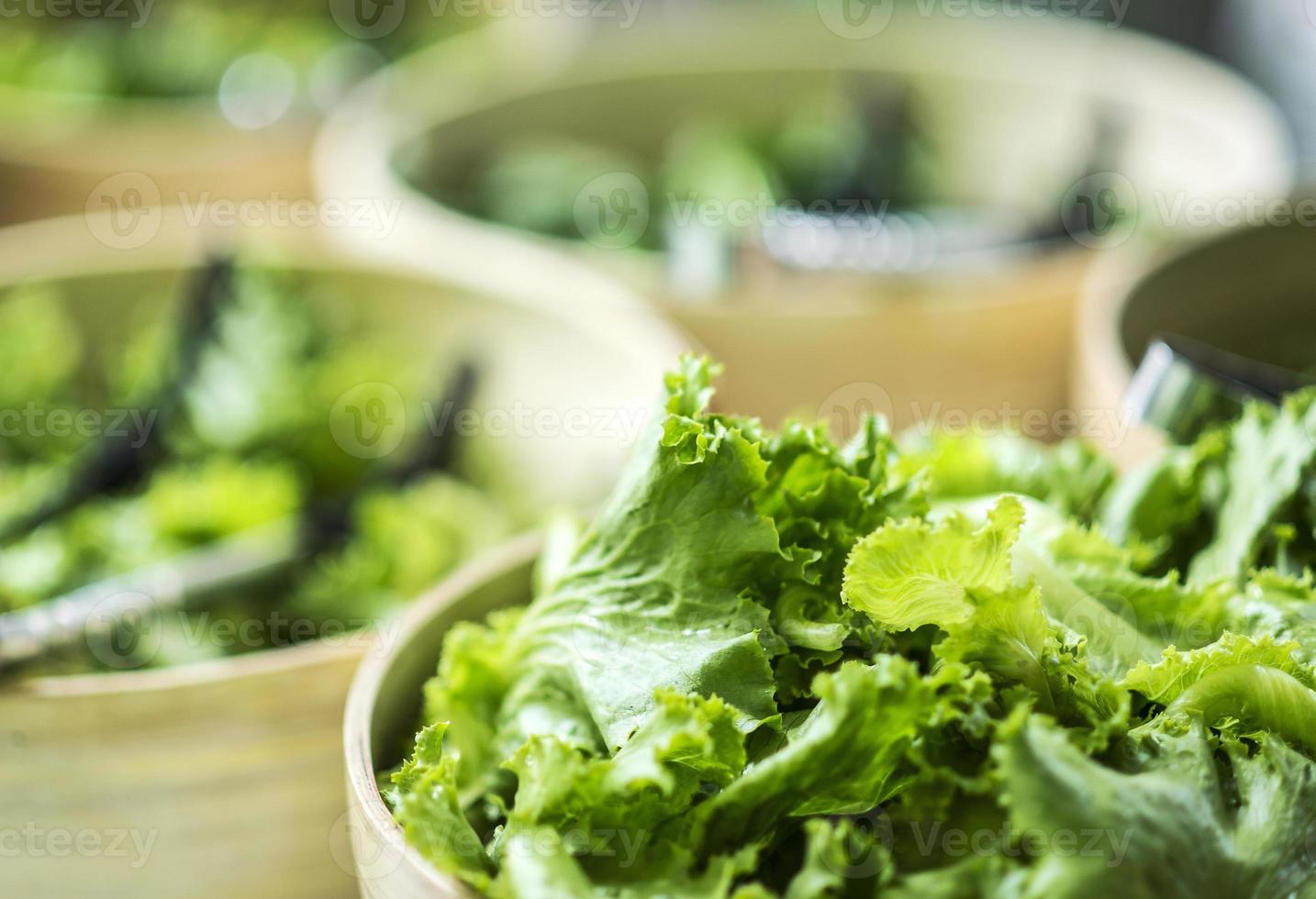 kommen verse biologische groene slabladeren in de weergave van de saladebar foto