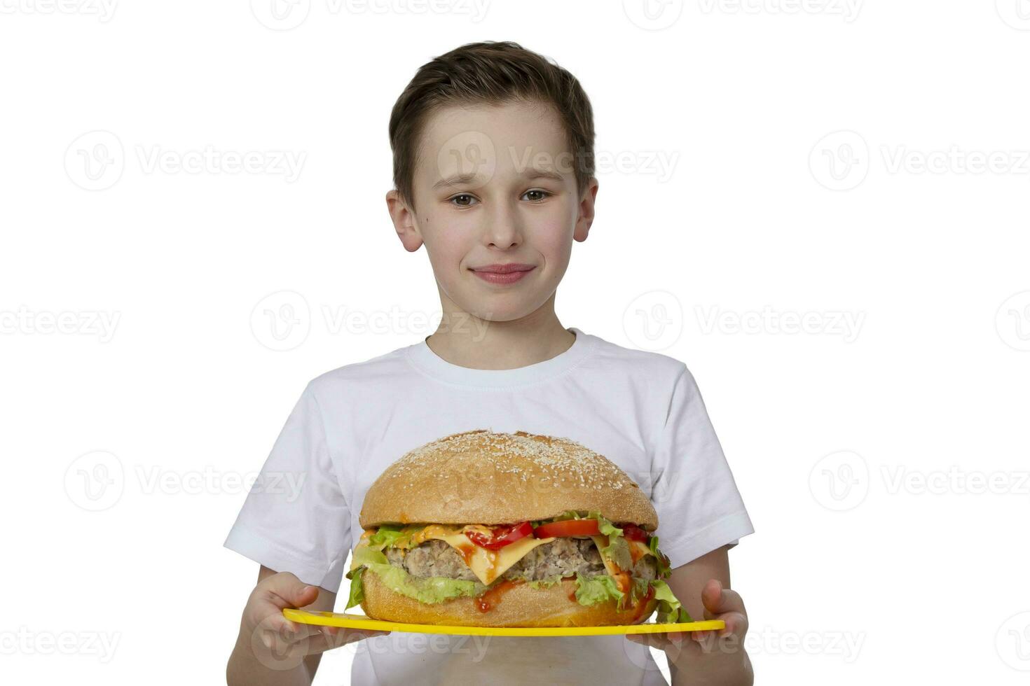 jong jongen met groot Hamburger geïsoleerd in wit. een tiener is Holding een burger.creatief hamburger. foto