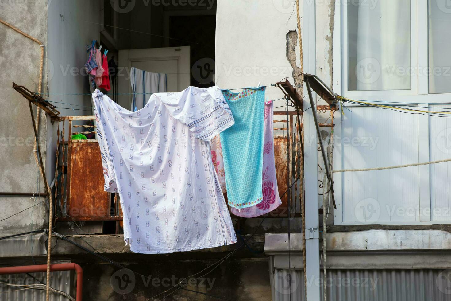 wasserij blijft hangen naar droog Aan een oud haveloos balkon. foto