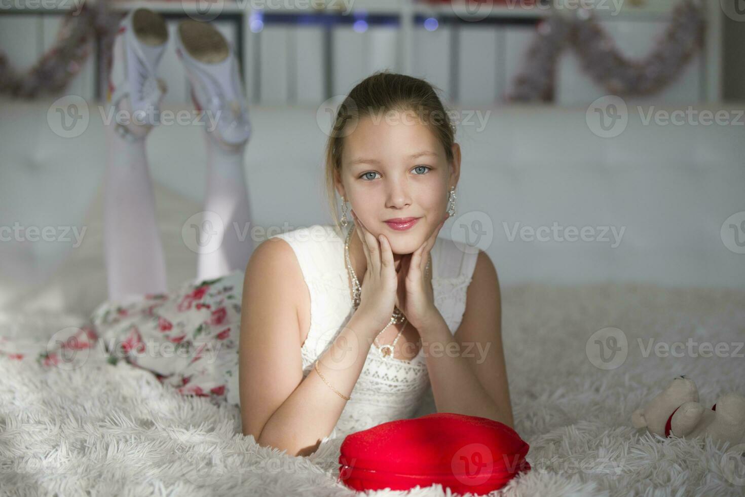 heel mooi tiener meisje aan het liegen Aan een bed met een rood hart kussen.jong dame foto