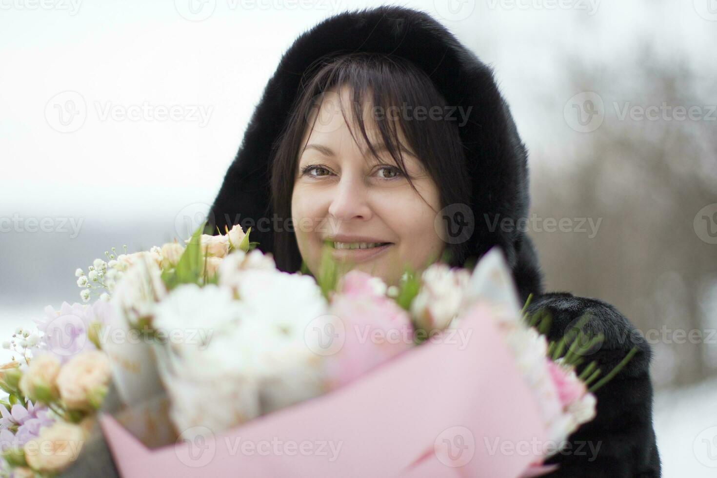 middelbare leeftijd vrouw met een boeket van bloemen in winter foto