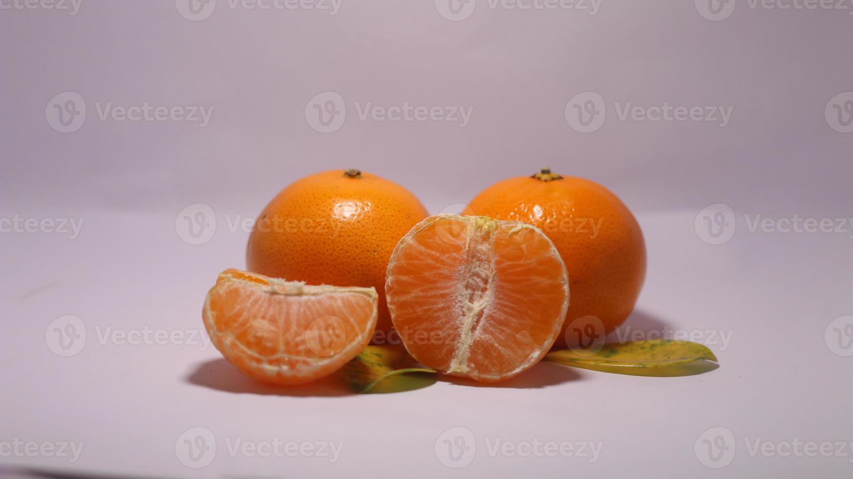 geheel en heeft rijpe sinaasappelen op een witte achtergrond met uitknippad. foto