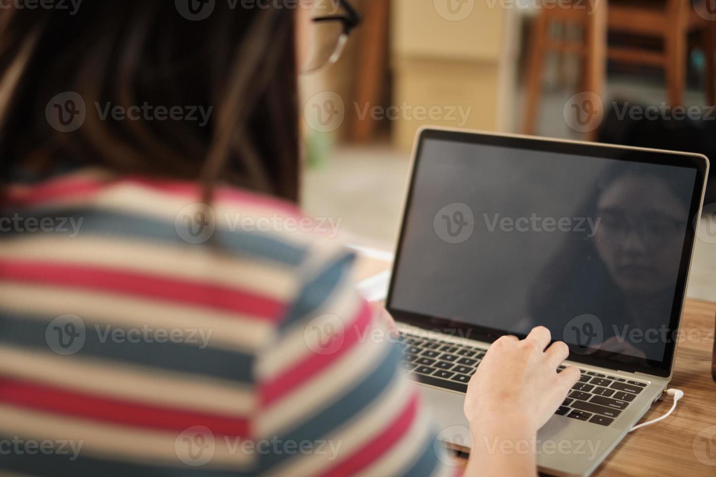 leeg ruimtescherm, freelance aziatische vrouw die wacht om de laptop te starten. foto
