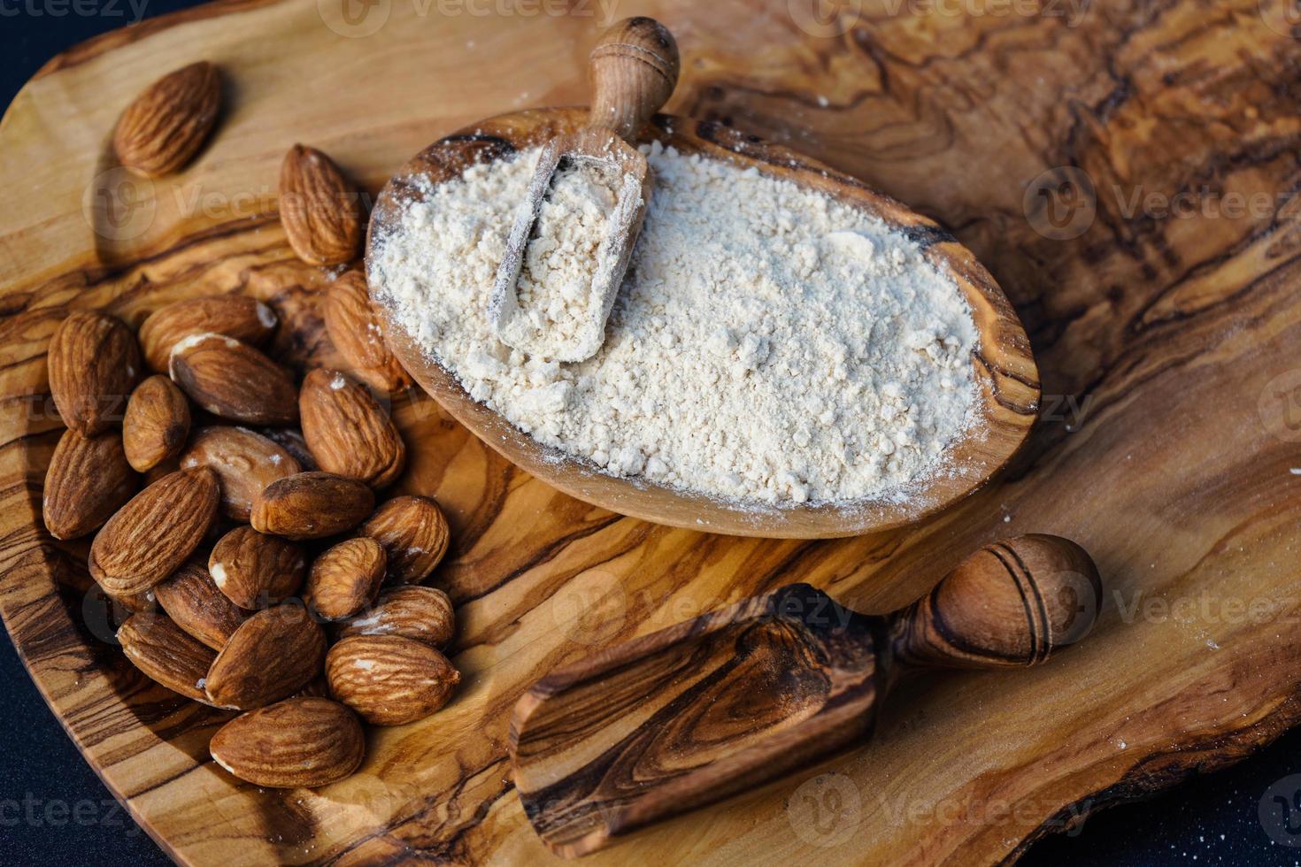 een stapel gepelde amandelen op olijfhout foto