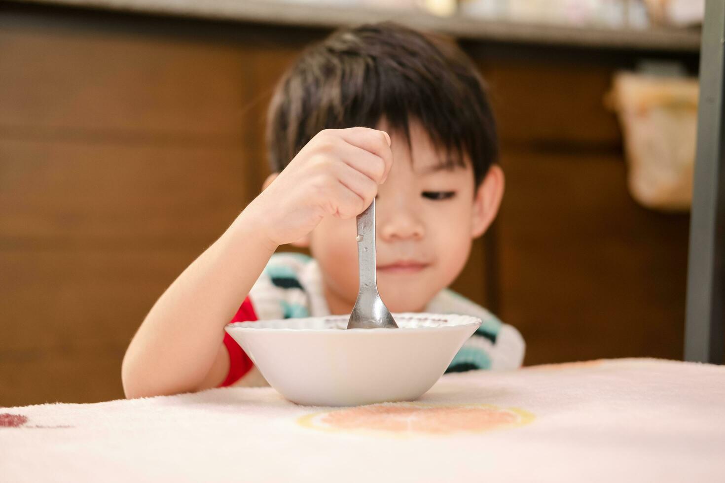 de gezicht van een Aziatisch kind aan het eten rijst- foto