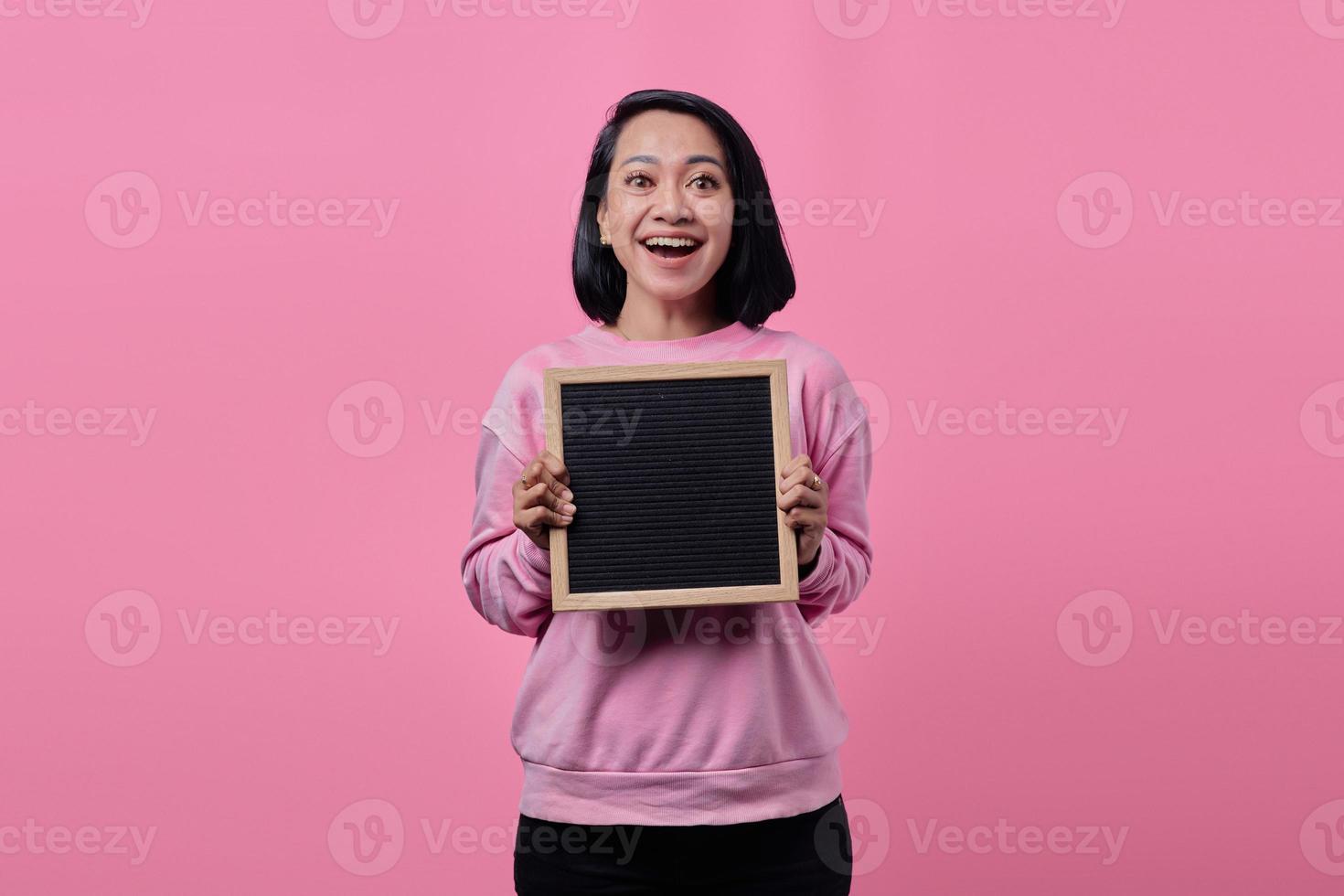 portret van een aziatische vrouw die een bord vasthoudt met een lachende uitdrukking foto