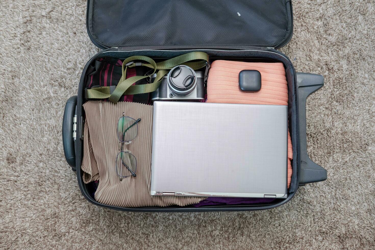 arrangement van kleren en accessoires in een koffer, reizen concept. foto