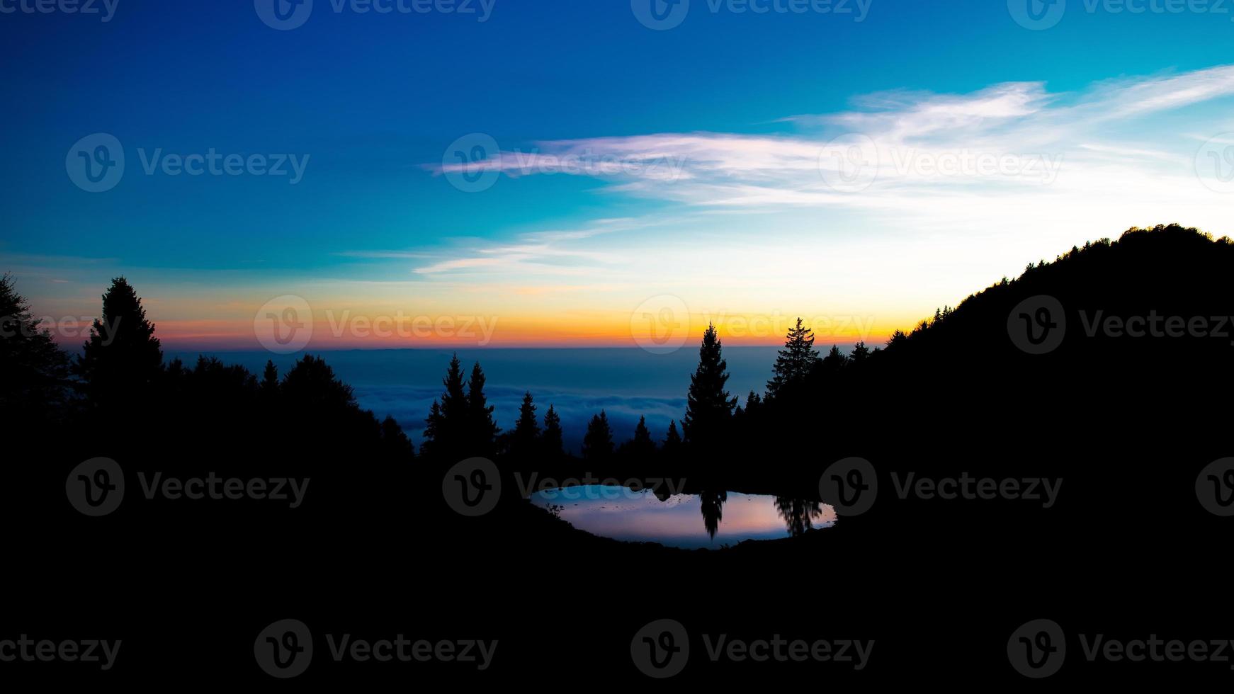 na zonsondergang de kleuren in een alpenlandschap met een meertje foto