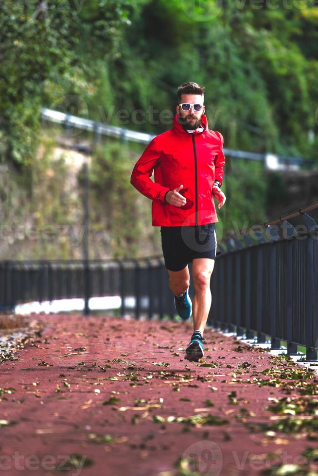 een atleet rent in de herfst over het fietspad foto