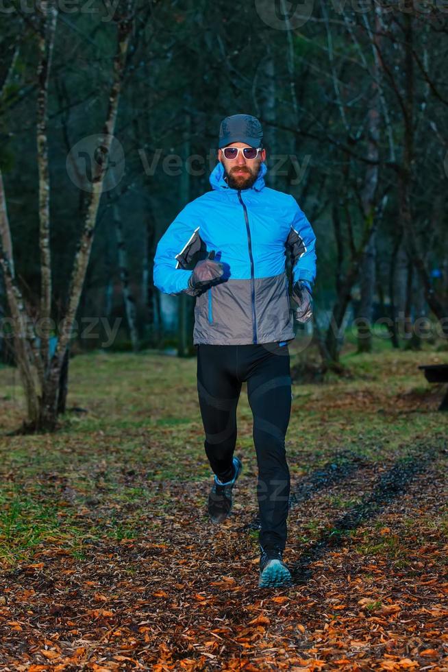 jonge man atleet tijdens een run in het bos foto