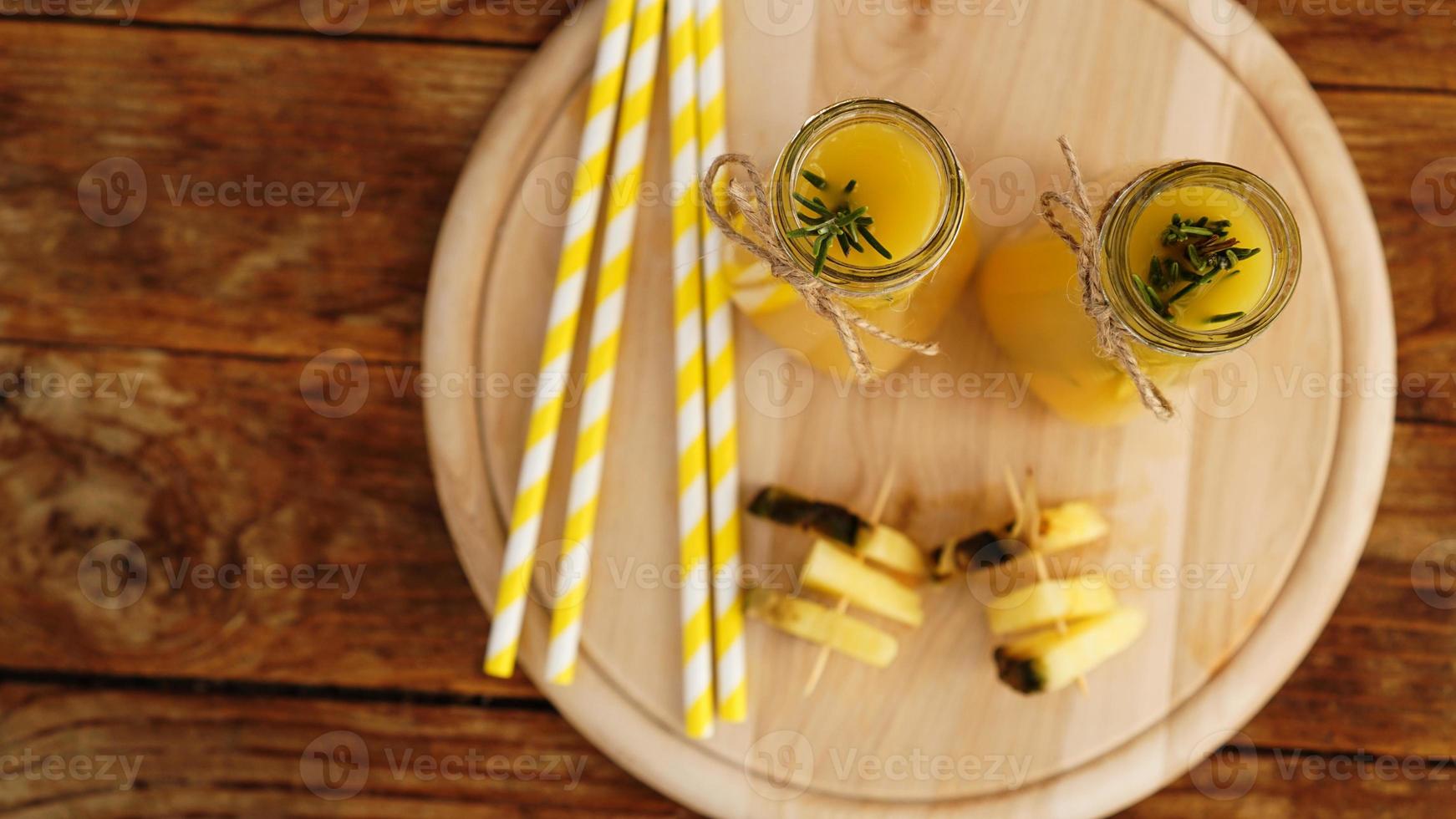 flessen ananassap op een houten tafel. foto