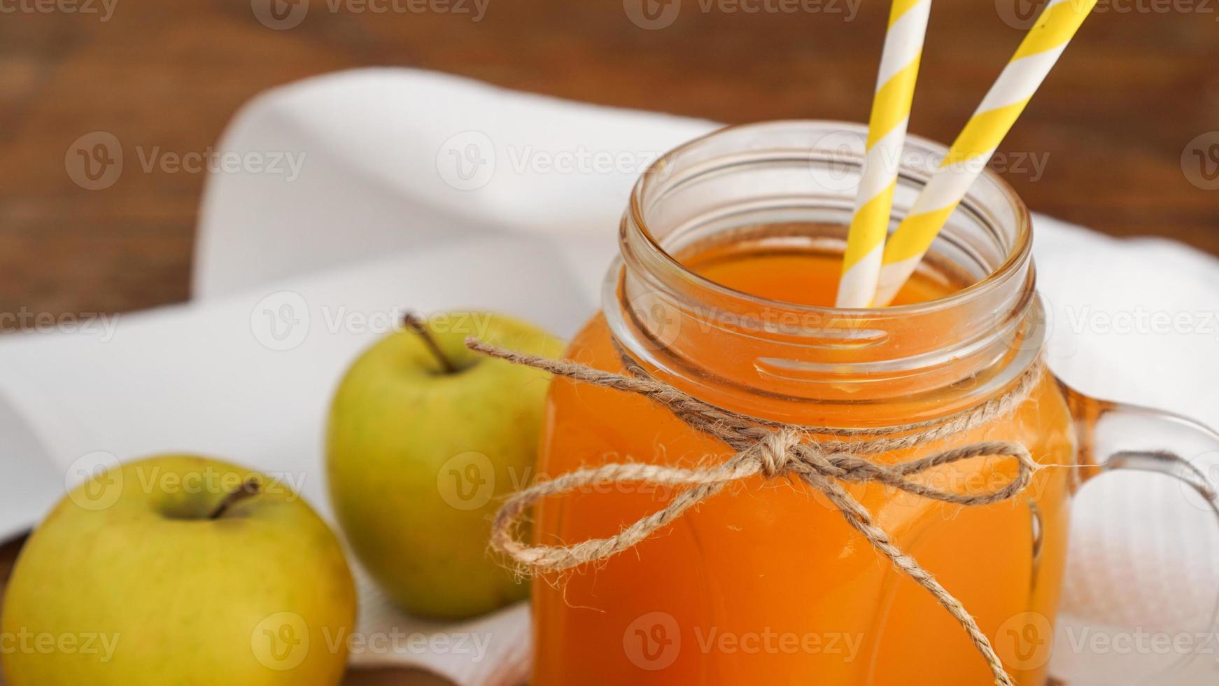 appel- en wortelsap in glas, verse groenten en fruit op houten foto