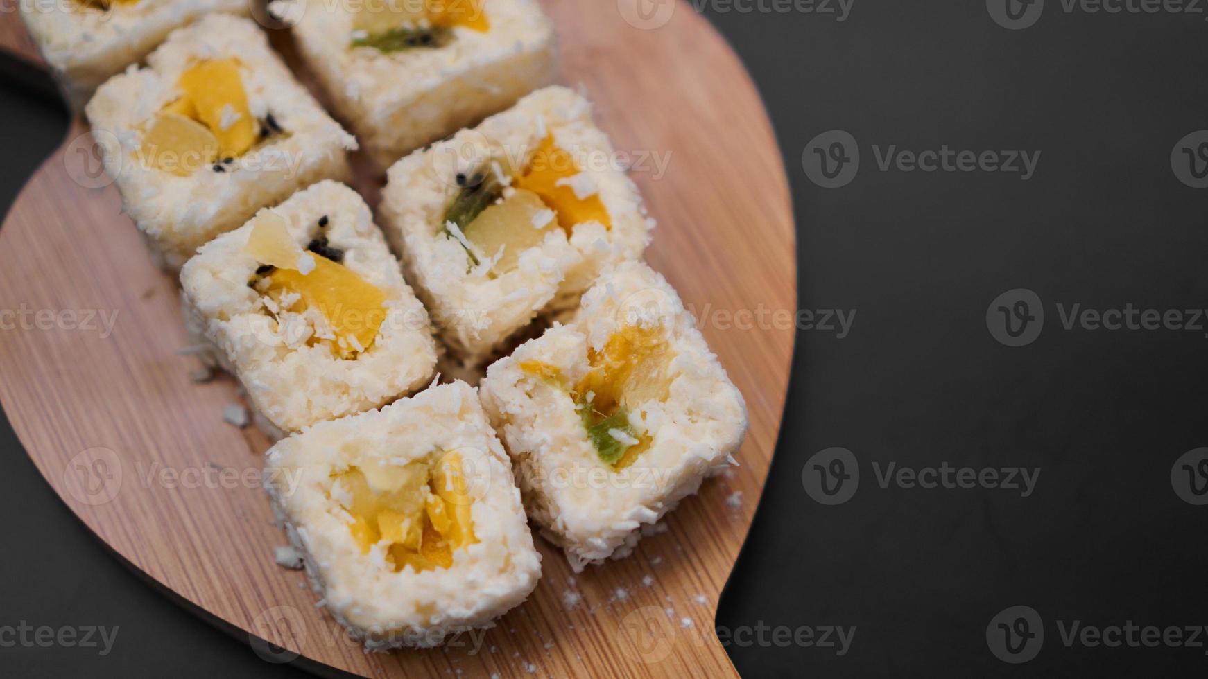 sushi bezorgen. zoete broodjes gemaakt van rijst, ananas, kiwi en mango. foto