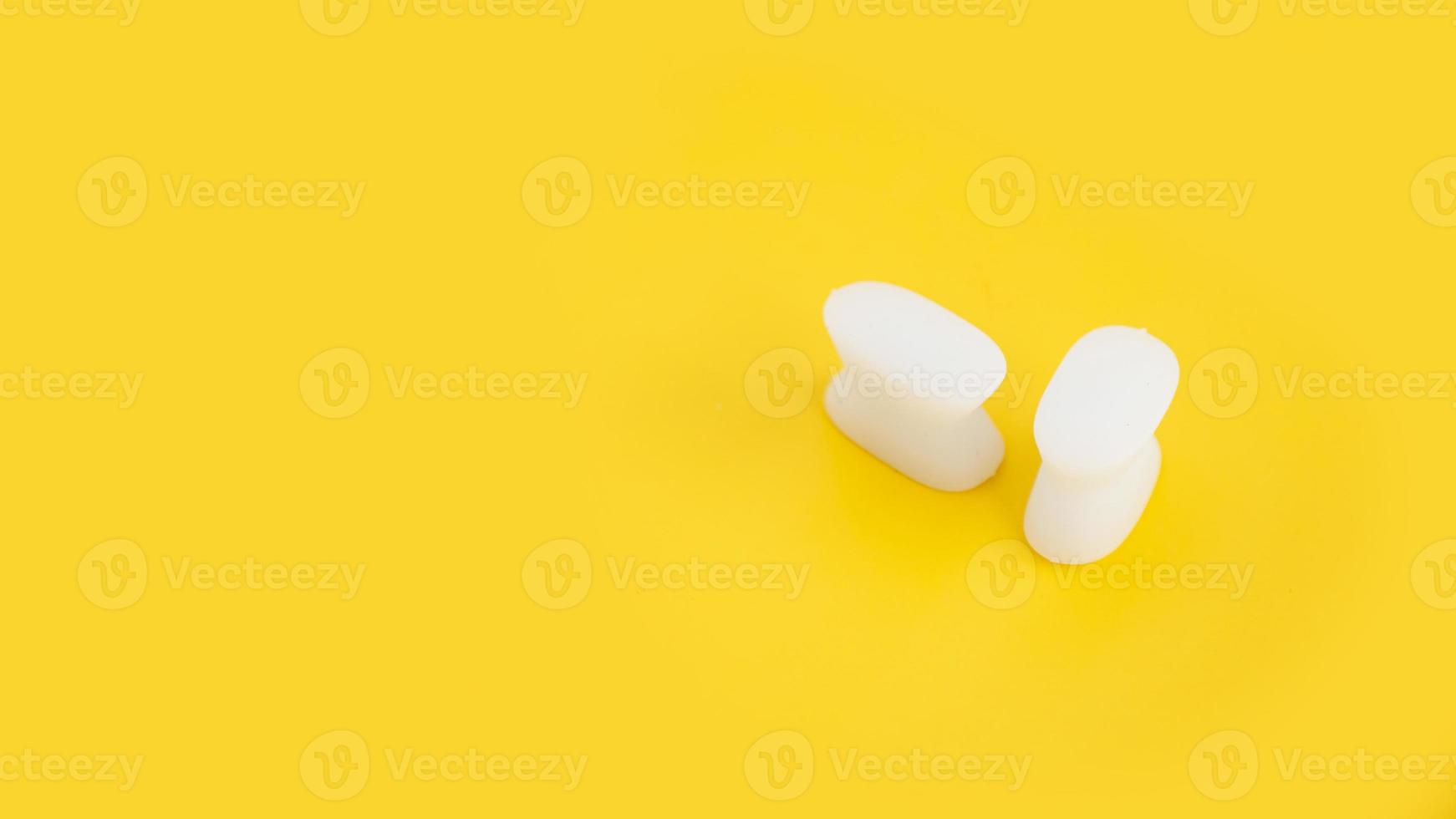 witte siliconen vingerverdeler op een gele achtergrond foto