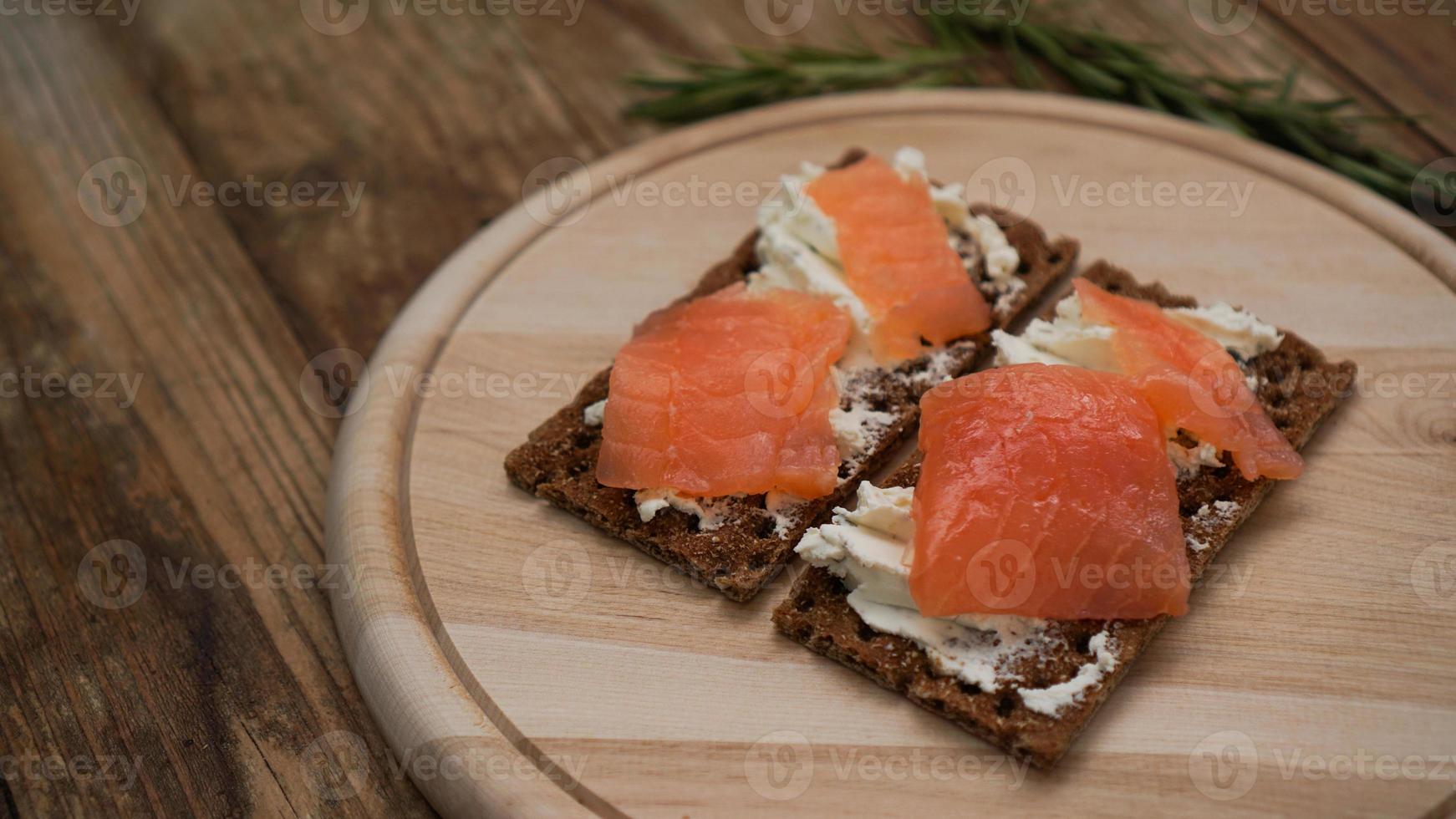 broodjes met zalm op houten snijplank foto