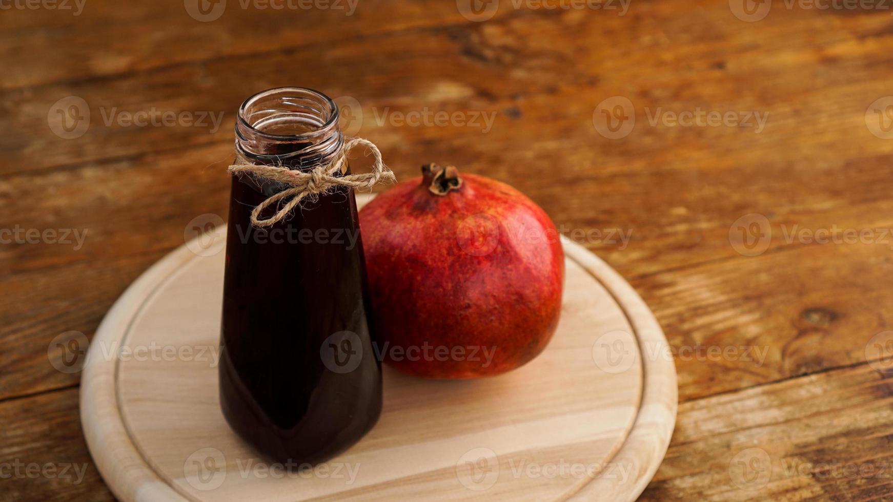 rijpe granaatappels met sap op houten achtergrond. foto