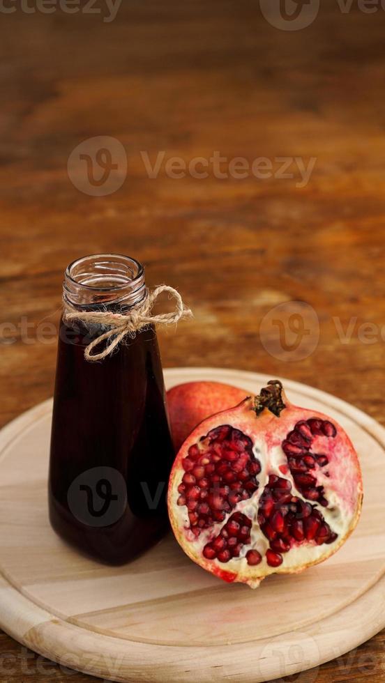 rijpe granaatappels met sap op houten achtergrond. foto