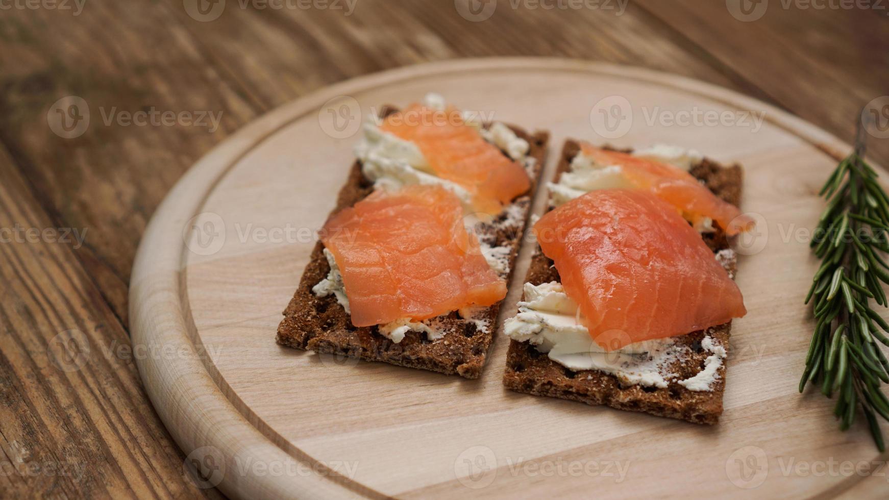 broodjes met zalm op houten snijplank foto