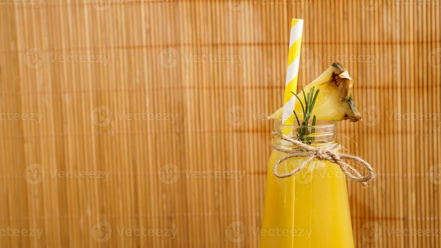 ananassap in een klein flesje. ananasschijfjes versieren de drank foto