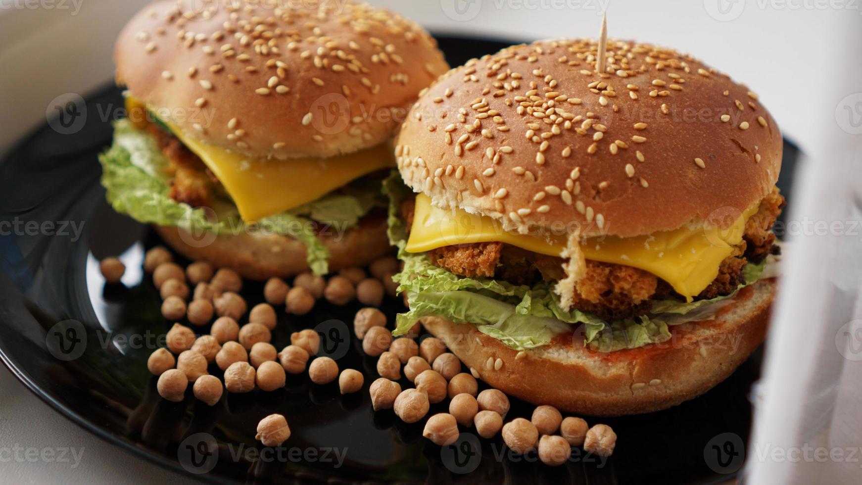 groenteburger met kikkererwtenkotelet. twee hamburgers op zwarte plaat foto