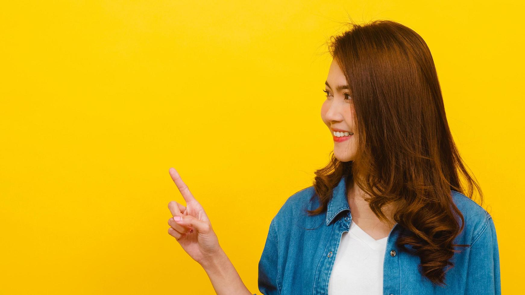 Aziatische vrouw met positieve uitdrukking op gele achtergrond. foto