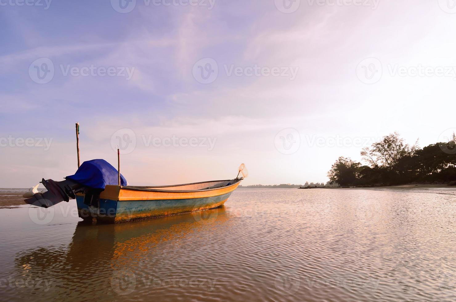 boot bij het strand als de zon ondergaat foto