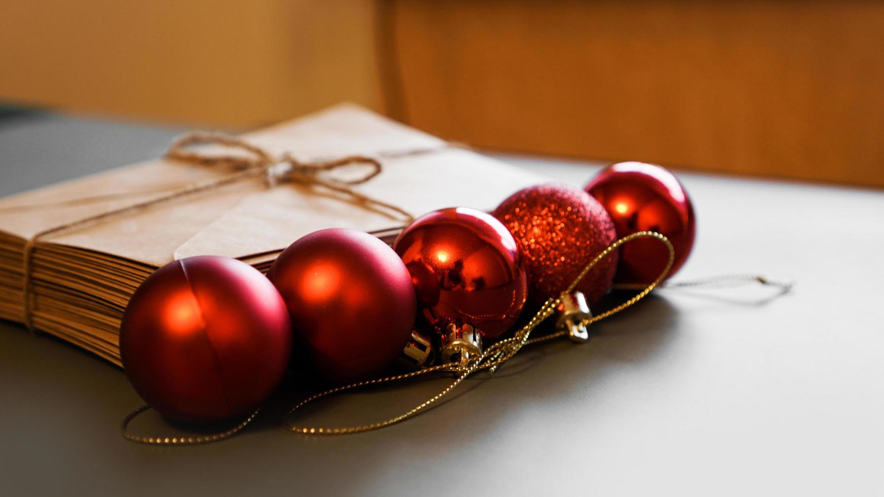 kerst compositie. ambachtelijke enveloppen en rode ballen. stapel brieven foto