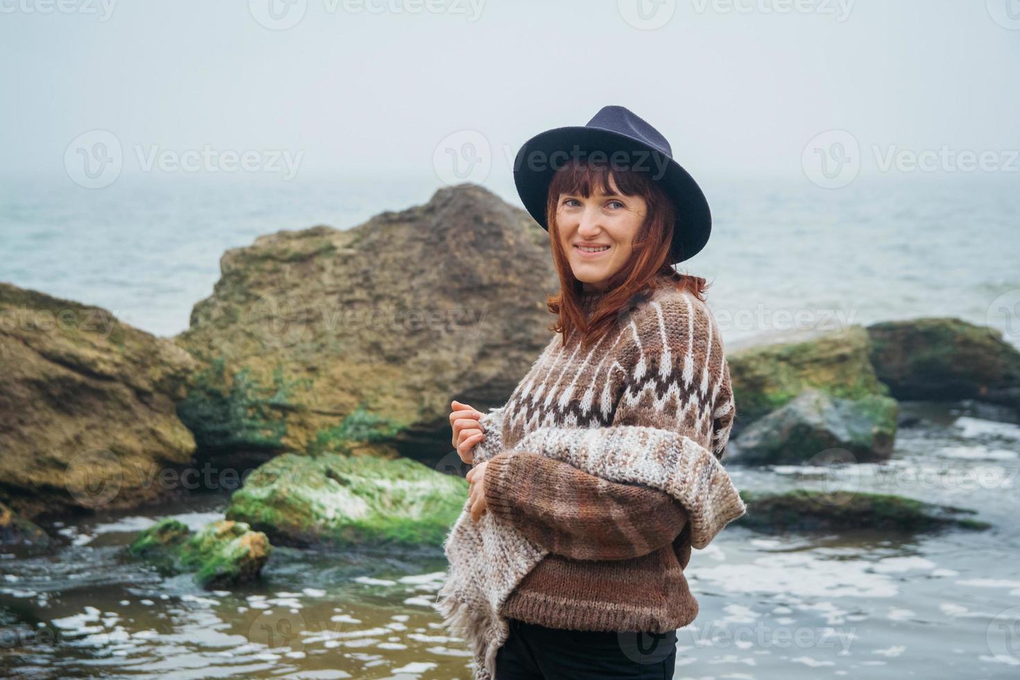portret van jonge vrouw in hoed op een rots tegen een prachtige zee foto