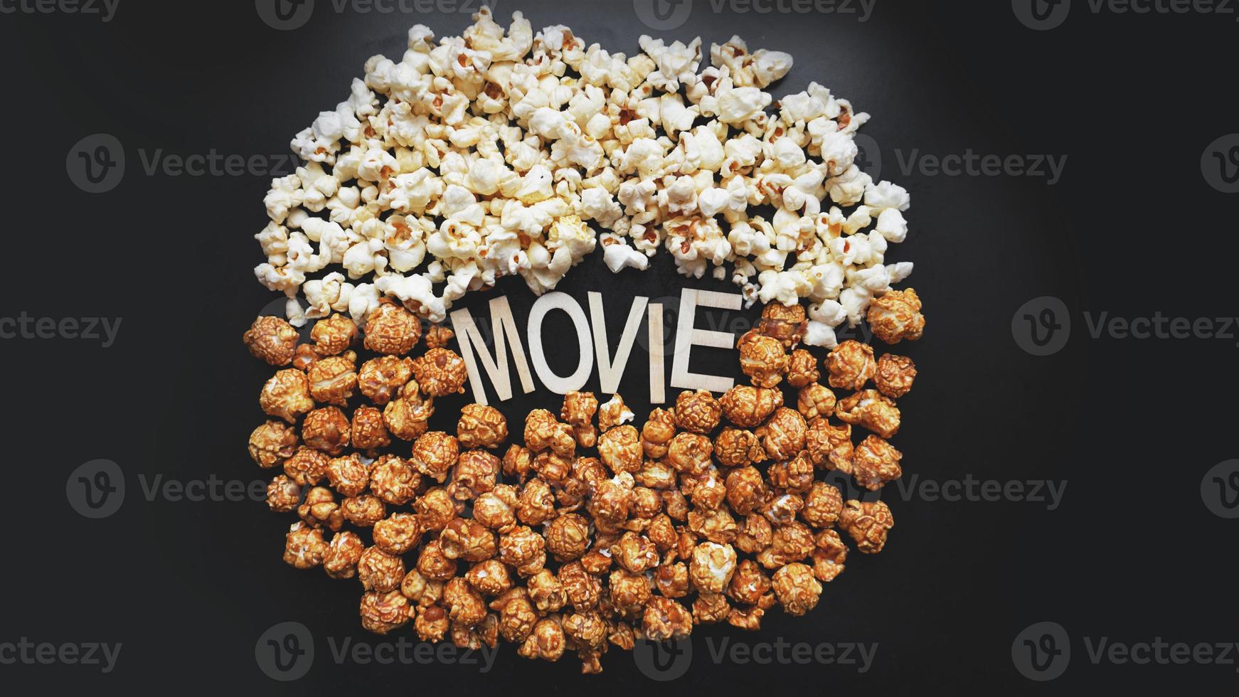 popcorn op zwarte achtergrond. een film kijken met popcorn. kopieer ruimte foto