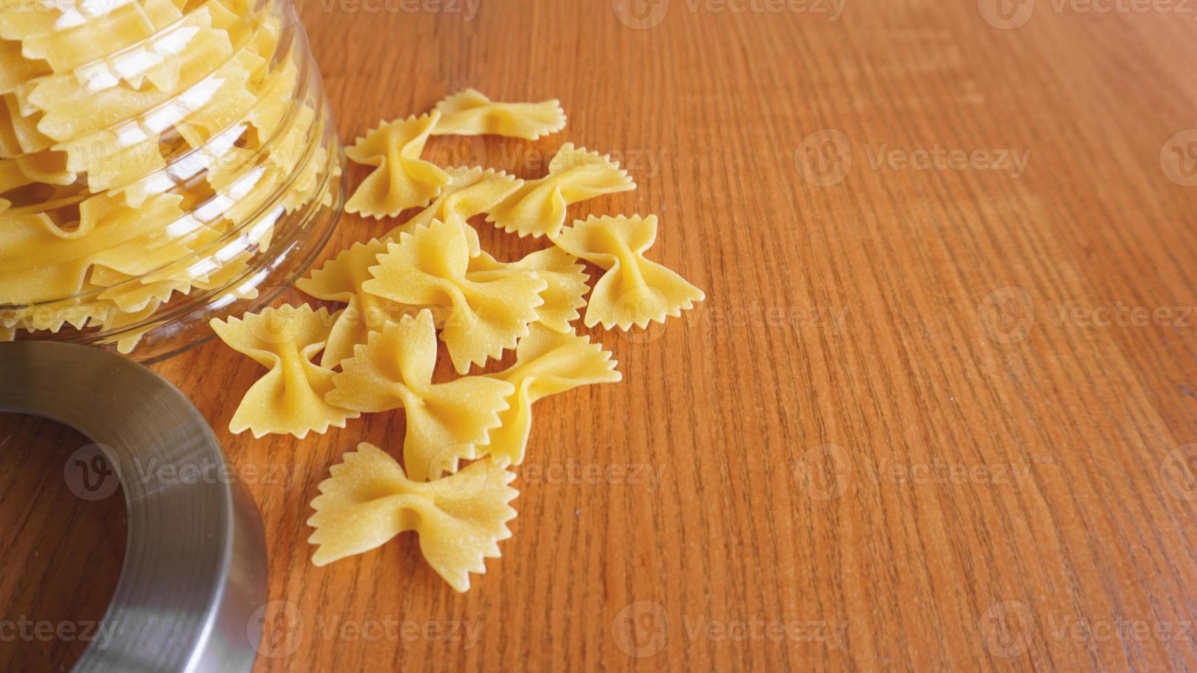 pasta in de vorm van strikken verspreid uit een glazen pot foto