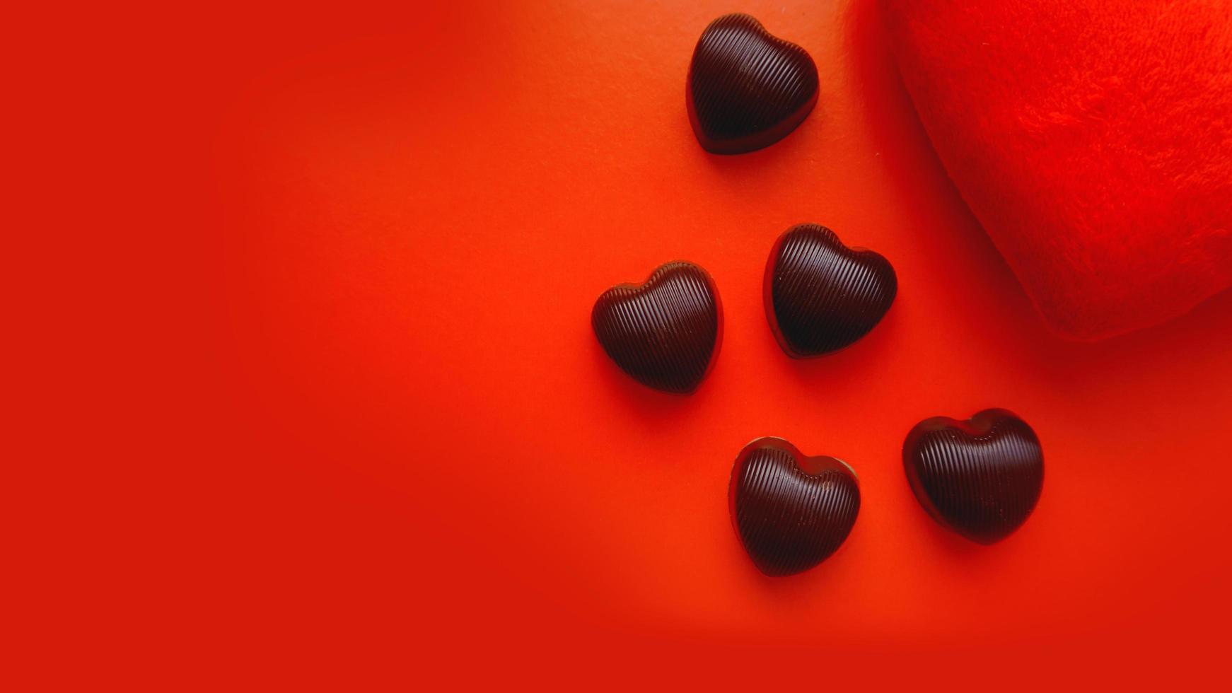Valentijnsdag achtergrond met zacht stuk speelgoed hart en chocolaatjes foto