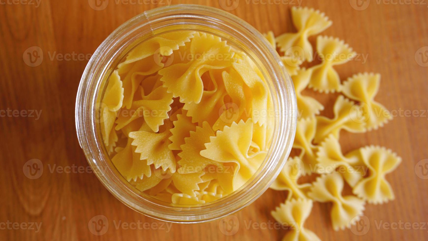 pasta in de vorm van strikken verspreid uit een glazen pot foto