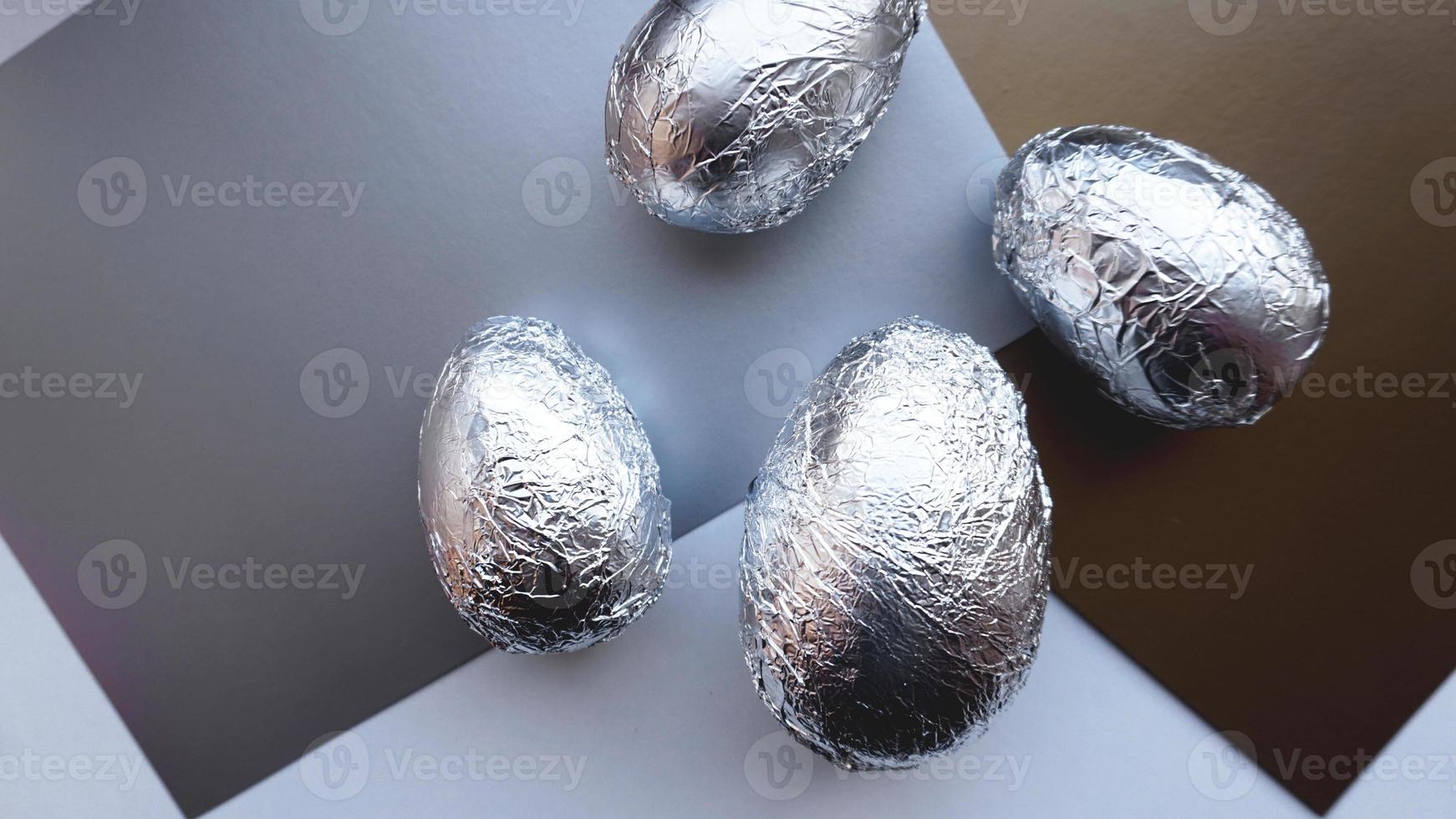 eieren in folie op zilveren achtergrond. Pasen concept foto