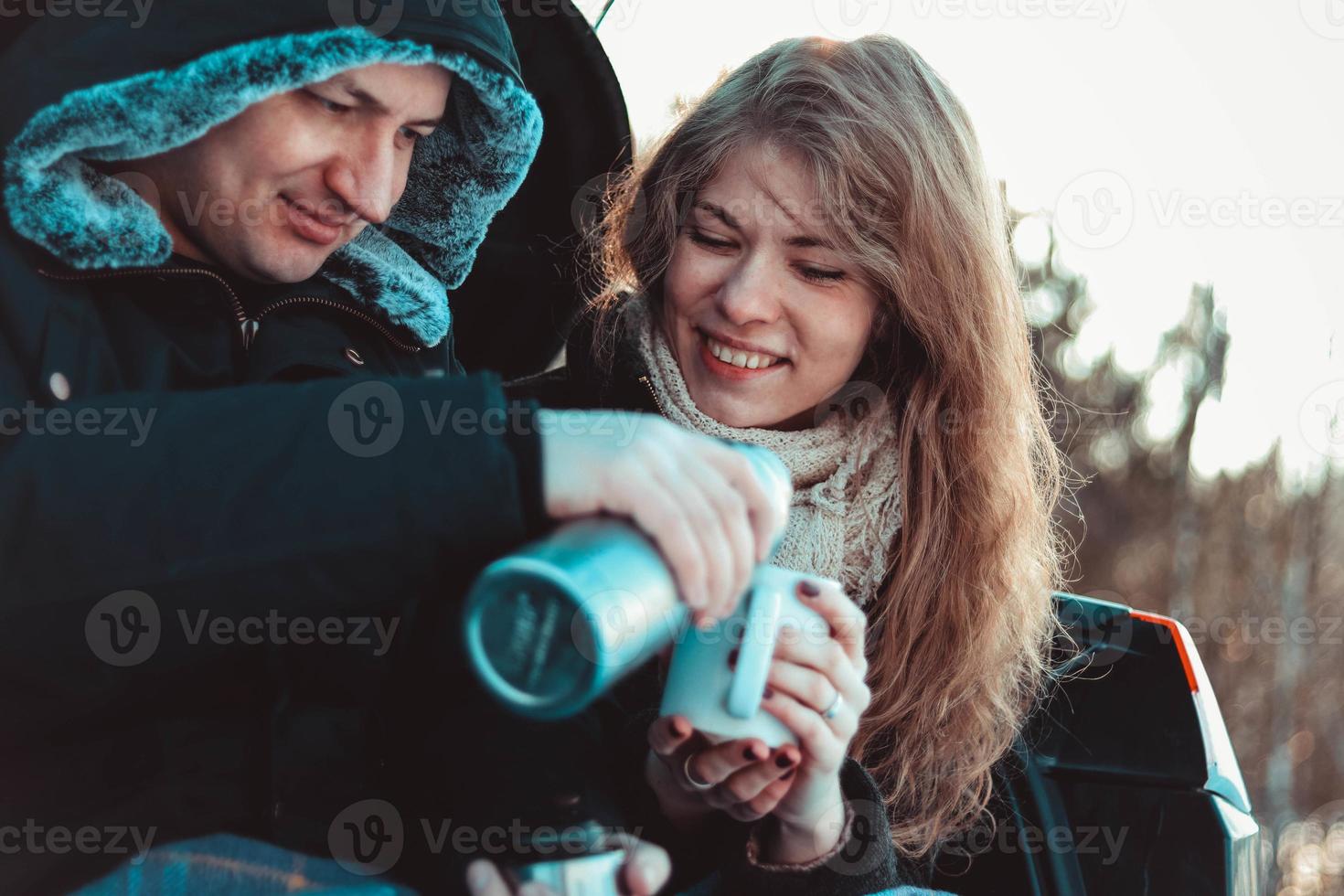 een man en een vrouw op de vrachtwagen van de auto. een gelukkig stel foto