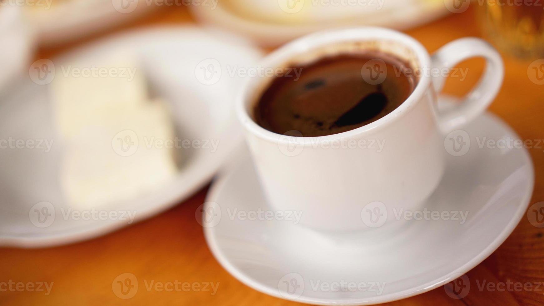 een kopje koffie in een witte kop op houten achtergrond foto